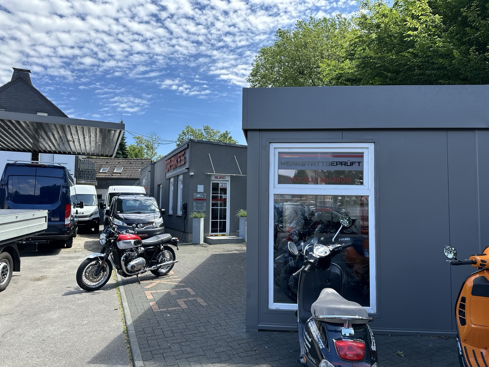 Hof mit Motorrädern und Transportern vor dem Büro